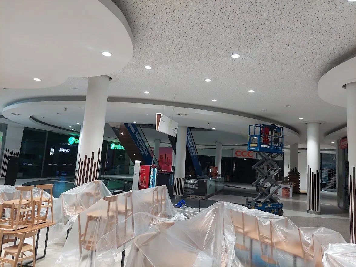 Interiér obchodného centra so zakrytým nábytkom počas maľovania